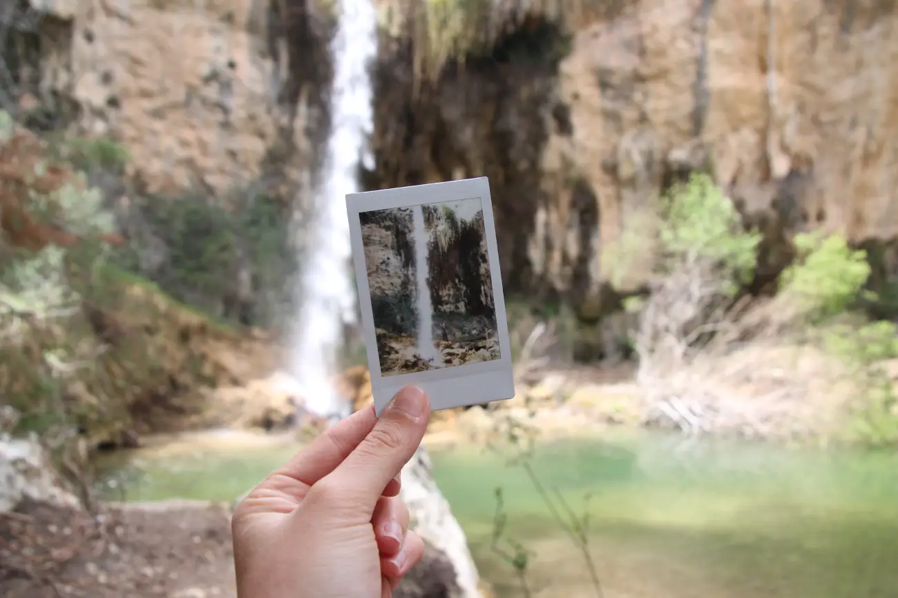 Foto polaroid con cascada de agua detrás